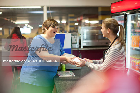 Young woman collecting takeaway order in cafe