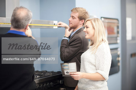 Young couple looking at ovens in showroom