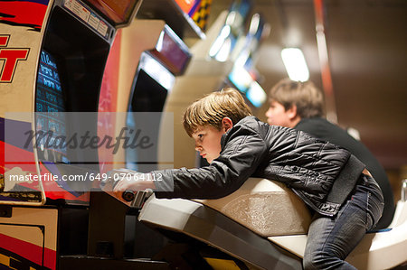 Two young brothers playing on driving video games