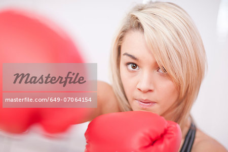 Portrait of young woman wearing boxing gloves