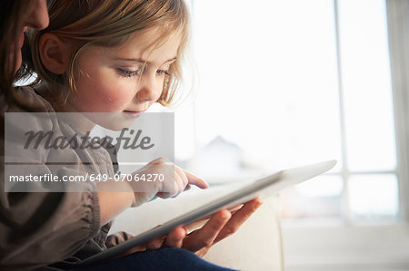 Mother and daughter using digital tablet