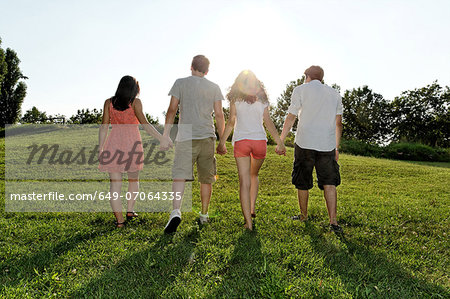 Group of young adults walking and holding hands