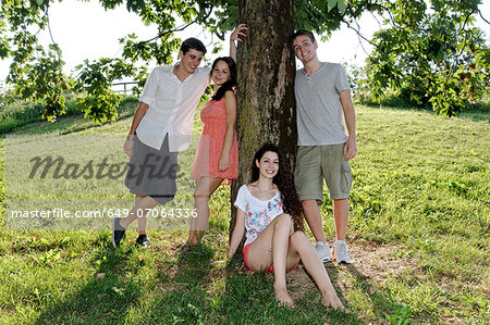 Portrait of young adults next to a tree