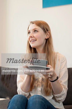 Portrait of young woman holding coffee cup in cafe