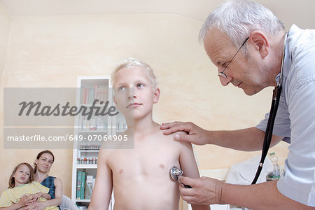 Boy being examining by doctor with stethoscope