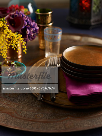 Plates Stacked on Table with Bowl of Olives, Studio Shot