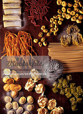 Assorted types of pasta on a wooden board