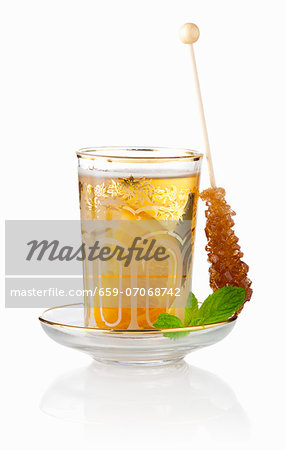 Tea Eastern-style with mint, orange and a stick of rock sugar Tea Eastern-style with mint, orange and a stick of rock sugar