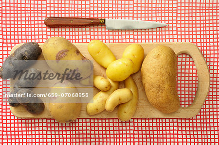 Assorted types of potato on a chopping board