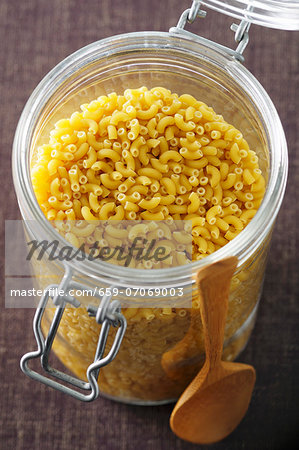 Lots of elbow macaroni in a storage glass