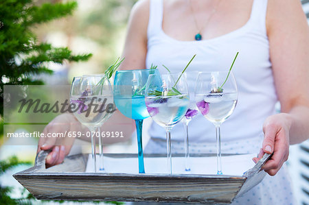 Lady holding a tray with several glasses of lavender water