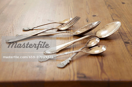 Silver cutlery on a wooden table Silver cutlery on a wooden table