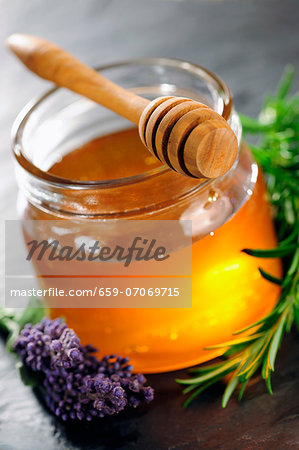 Honey jar with dipper, rosemary and lavender flower