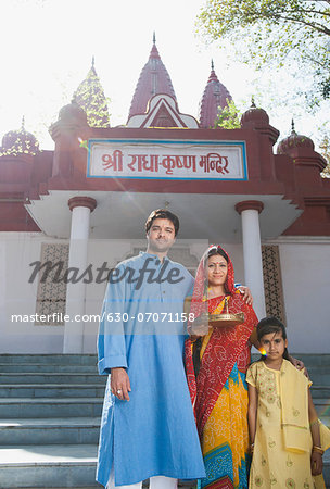 Rural family standing in front of a temple, Sohna, Haryana, India