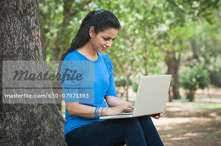 Woman using a laptop in a park, Lodi Gardens, New Delhi, Delhi, India