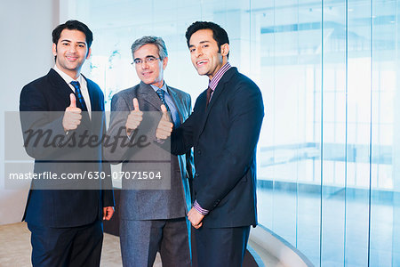 Businessmen showing thumbs up