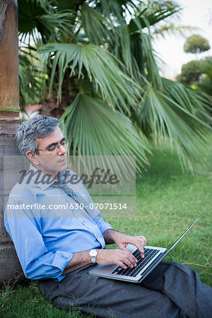 Businessman working on a laptop in a park