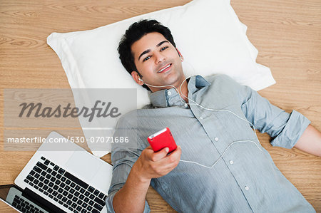 Man listening to music with a laptop beside him