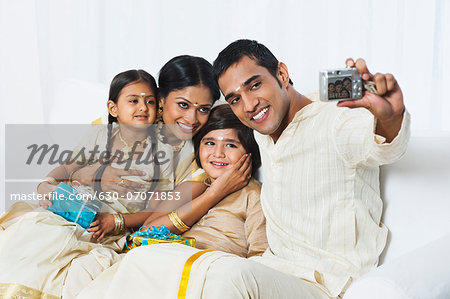 South Indian man taking a picture of his family at Onam
