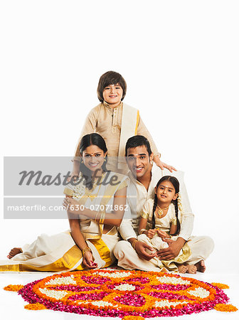 South Indian family making a rangoli of flowers at Onam