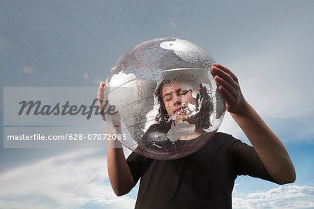 Girl holding transparent globe outdoors