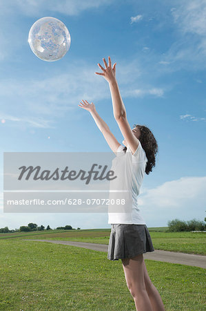 Girl playing with transparent globe outdoors Girl playing with transparent globe outdoors