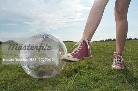 Girl standing in meadow with transparent globe