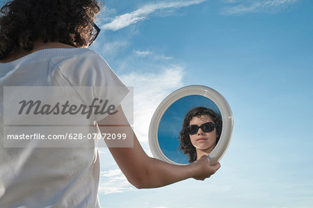 Girl outdoors holding mirror