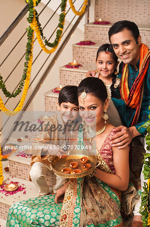 Family decorating with oil lamps on Diwali