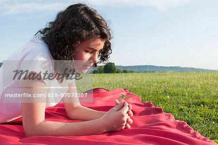 Girl lying on blanket in meadow