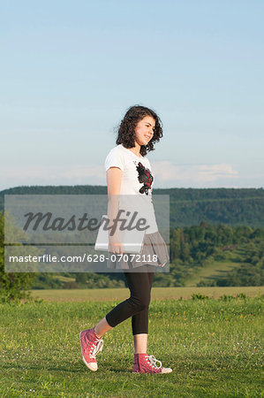 Girl walking with laptop in meadow