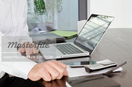 Businessman sitting at desk with laptop