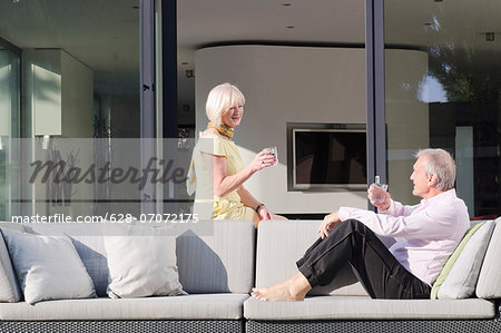 Senior couple with glasses of water on the terrace