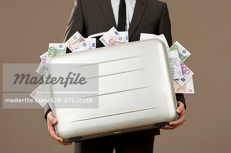 Businessman holding suitcase full of Euro notes