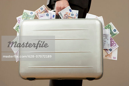Businessman holding suitcase full of Euro notes