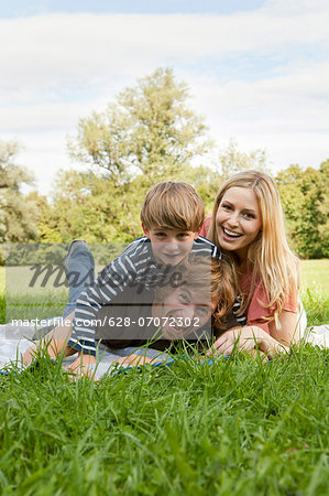 Happy family lying on blanket in meadow