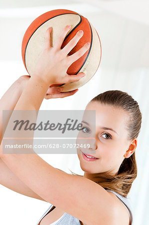 Smiling teenage girl holding basketball