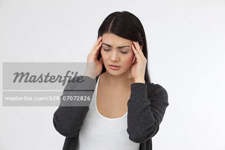 Serious young woman holding her head in hands