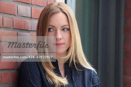 Blond woman at brick wall