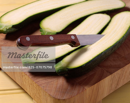 Cutting the zucchinis in two down the length and taking out the flesh