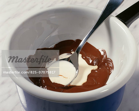 Mixing together the cream and the melted chocolate