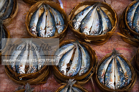 Baskets of cooked fish on a stall at the market in Luang Prabang, Laos