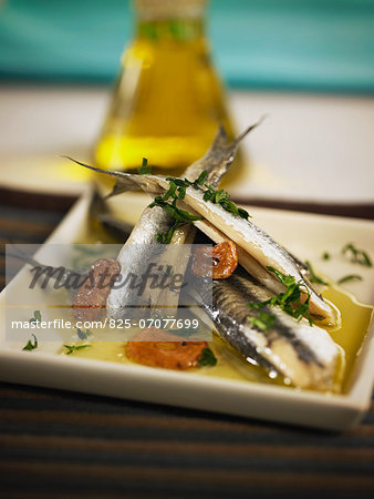 Plate of anchovies with red pepper,garlic and parsley Plate of anchovies with red pepper,garlic and parsley