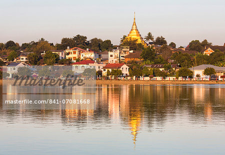 View of Kengtung (Kyaingtong) looking across Naung Tung Lake towards the town and gilded stupa of Wat Jong Kham bathed in evening light, Kengtung, Shan State, Myanmar (Burma), Asia