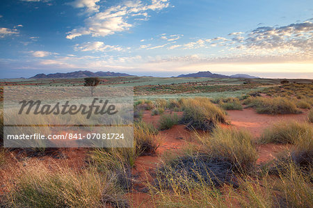 View across magnificent landscape of orange sand dunes and sandstones mountains at Wolwedans, part of the Namib Rand game reserve, Namib Naukluft Park, Namibia, Africa