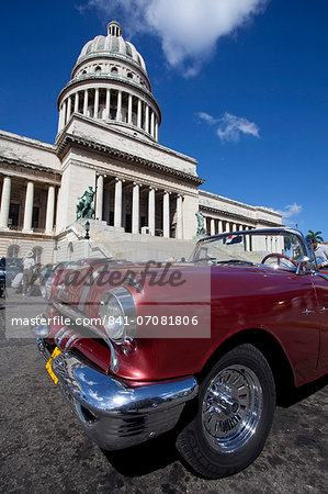 Red vintage American car parked opposite The Capitolio, Havana Centro, Havana, Cuba, West Indies, Central America