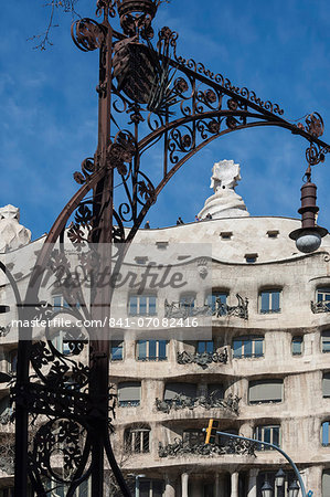 A wrought iron lamp frames La Pedrera (Casa Mila), an apartment block designed by Antonio Gaudi, UNESCO World Heritage Site, Passeig de Gracia, Barcelona, Catalunya, Spain, Europe