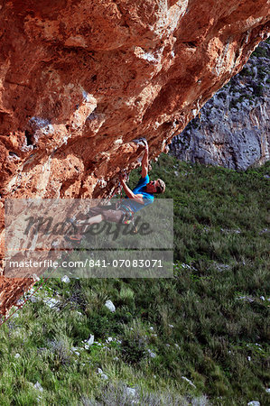 A climber scales cliffs near San Vito Lo Capo, northwest Sicily, Italy, Europe