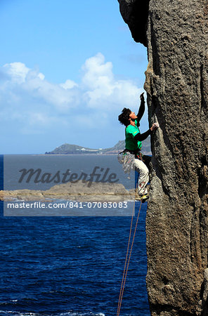 A climber scales cliffs at Sennen Cove, Cornwall, England, United Kingdom, Europe