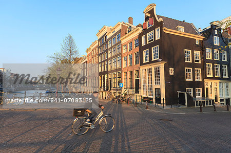 Cyclist crossing a bridge over Keizersgracht Canal, Amsterdam, Netherlands, Europe